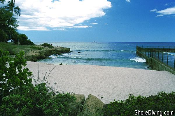 The entry is off a sandy beach area, North of the shelter, and South of cooling water outlet of the electric plant.