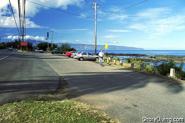 A parking lot is right along the main road.  The cove entry is on the North side, and the restrooms and showers are on the South.