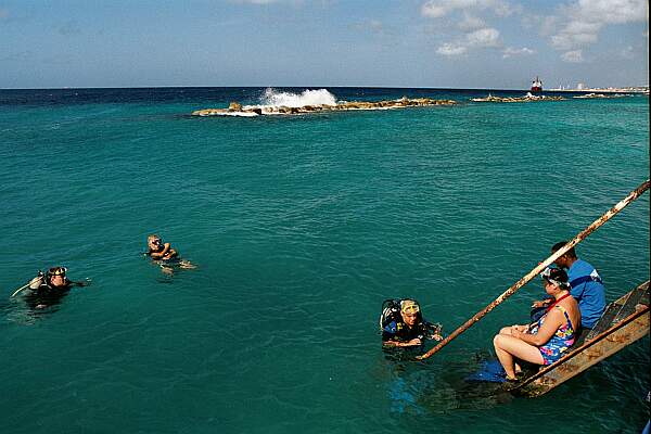 Check in with the dive shop when you arrive, and ask if it is ok for you to use their dock.  You may have to show your certification card and sign a waiver.