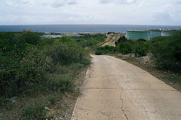 This picture is looking South, back toward at the turn-off at the storage tanks.  The road is well-maintained dirt and gravel, with concrete paving on the hills and ravines.