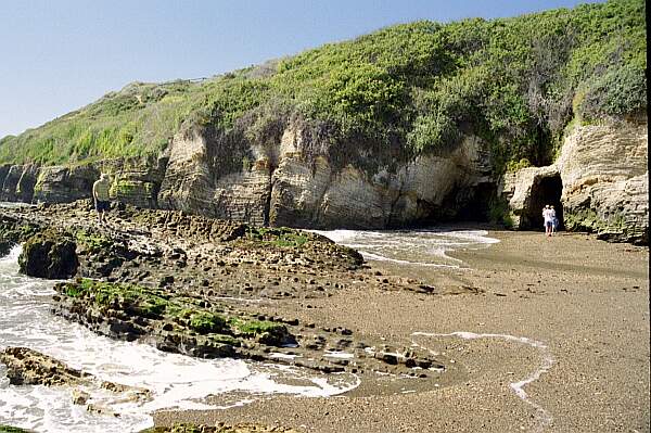 The rocky channels should only be attempted during periods of calm.  Otherwise, stick to the sandy beach to the left.  Remember that the beach opens to the West-Northwest, so you can expect swells.  If you have experience 'reading' the Pacific ocean, you'll be able to time your entry and exit.  If you aren't comfortable in these conditions, find a local guide to help you out.